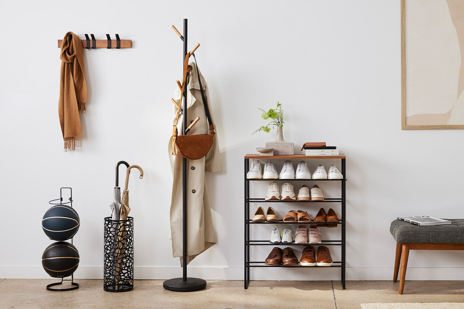 Yamazaki Home umbrella stand and 6-tier shoe rack and coat rack on a floor and key storage and a clock on a wall. 