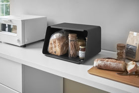 Black Yamazaki Bread Box with Cutting Board Lid open with bread and jam inside view 14