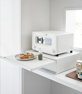 Countertop Drawer with Pull-Out Shelf by YamazakI Home in white with the shelf pulled out. A toaster sits atop the unit and a plate of food is placed on the shelf. view 8