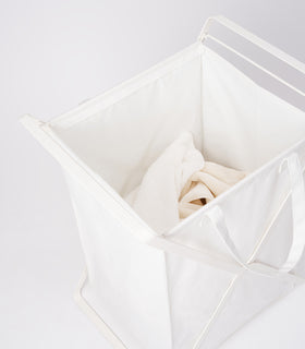 Large Laundry Hamper with Cotton Liner by Yamazaki Home in white on a white background with white towels inside. view 16