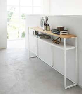 White Yamazaki Home Long Console Table - Shelf against a wall with books and decorations on it view 17