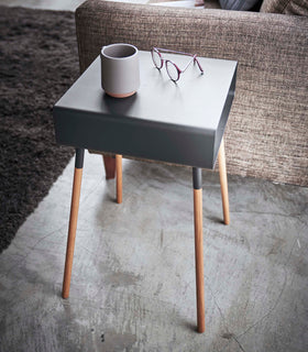 Side view of black Storage table holding coffee cup and glasses in living room by Yamazaki Home. view 15