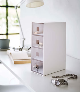 White Yamazaki Home Storage Tower with Drawers closed and filled with accessories view 2