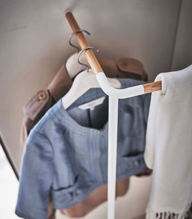 Top-down view of Yamazaki white Corner Leaning Coat Hanger with clothes hung on it view 5