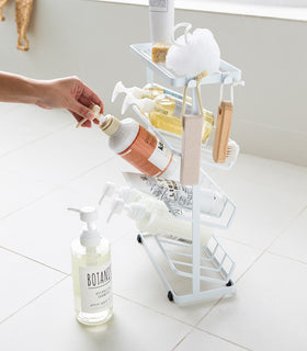 Side view of white Freestanding Shower Caddy holding shower products in bathroom by Yamazaki Home. view 10