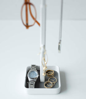 Close up of white Yamazaki Home Tree Accessory Stand displaying a watch and rings view 4
