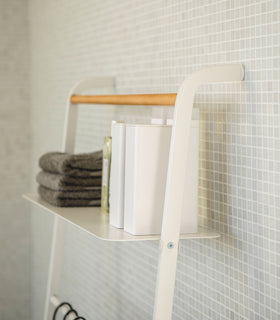 Close up side view of white Leaning Ladder Rack holding towels and containers in bathroom by Yamazaki Home. view 12