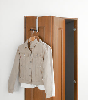 White Over-the-Door Hook holding jackets on door by Yamazaki Home. view 7