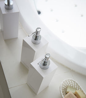 Aerial view of square soap dispenser in three styles by bathtub view 16