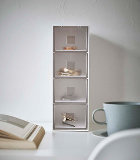 Frontal view of white Yamazaki Home Storage Tower with Drawers filled with accessories view 4