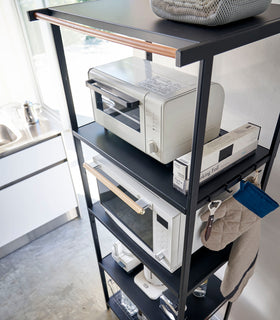 Aerial view of tall black five-tier steel storage rack with a decorative wood accent bar on top shelf and black adjustable hooks on sides. view 33