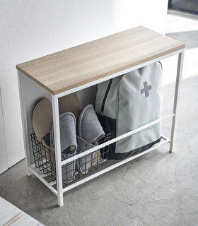 White Yamazaki Discreet Entryway Storage Shelf filled with slippers and a backpack view 4