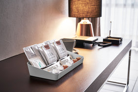 Side view of white Accessory Tray holding tea bags and espresso pods on desk by Yamazaki Home. view 13