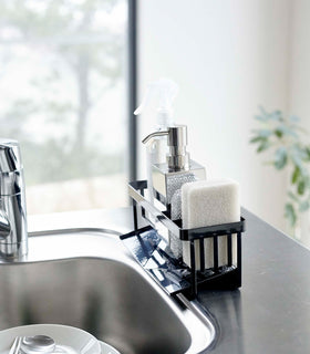 Profile of black steel sponge and soap bottle holder with white draining tray. view 12