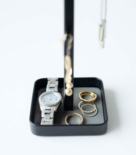 Close up of black Yamazaki Home Tree Accessory Stand containing rings and a watch view 11