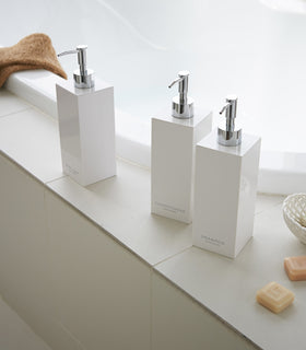 White Yamazaki Home square soap dispenser in three styles by bathtub view 3