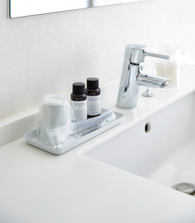 Flat white Accessory Tray holding soap, cup, and toothbrush on bathroom sink countertop by Yamazaki Home. view 13