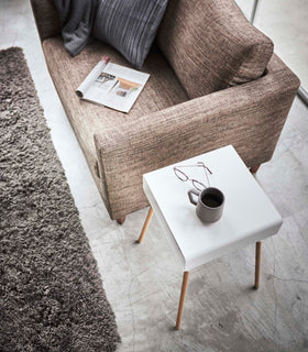 Aerial view of white Storage Table holding glasses and coffee in living room by Yamazaki Home. view 10