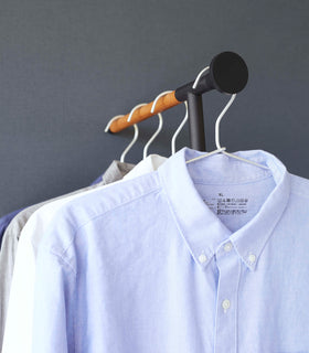 Close up of black Yamazaki Home Clothes Steaming Leaning Pole Hanger with collared shirts hung view 13