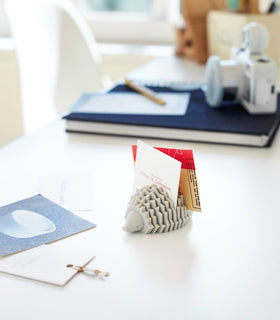 Gray Hedgehog Business Card Hold holding cards on office desk by Yamazaki Home. view 2