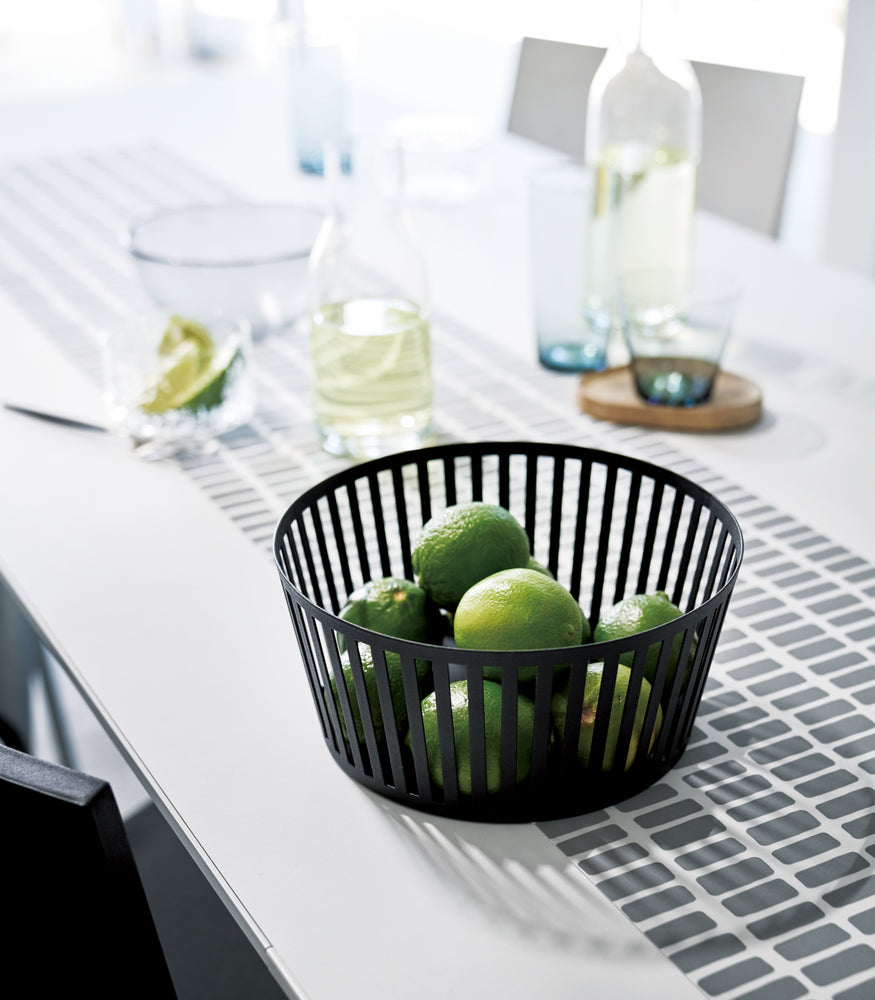 View 17 - Black Fruit Basket holding limes on dining room table by Yamazaki Home.