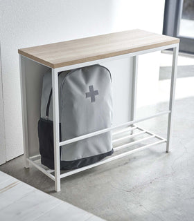 White Yamazaki Discreet Entryway Storage Shelf with a backpack inside view 3