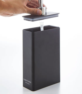 Black Conditioner Dispenser with top removed on white background by Yamazaki Home. view 18