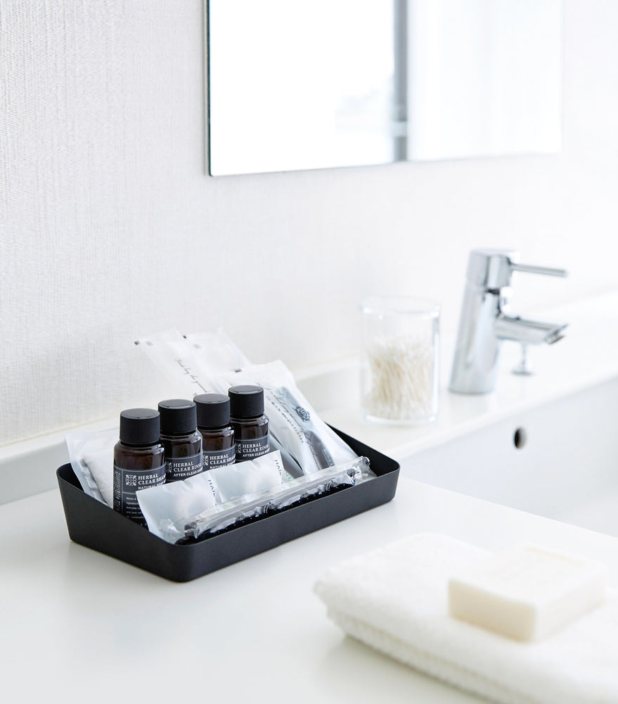 View 15 - Black Accessory Tray holding beauty products in bathroom by Yamazaki Home.