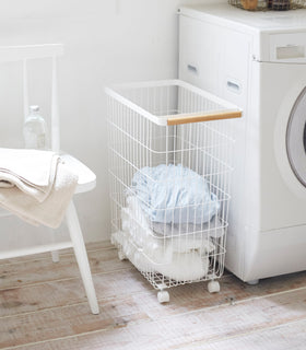 Rolling Wire Basket holding clothes in laundry room by Yamazaki Home. view 4