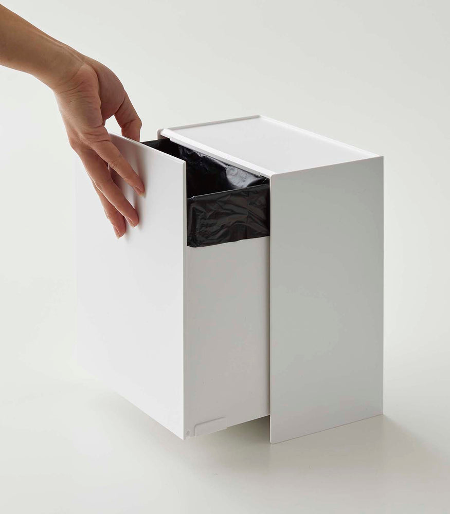 View 6 - Person adjusting bin drawer on white Wall-Mount Storage on white background by Yamazaki Home.