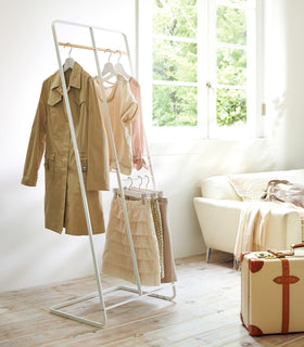 White 2-level Coat Rack holding clothes in room by Yamazaki Home. view 2