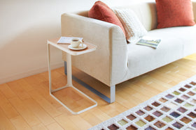 White C Side Table holding book and coffee near living room couch by Yamazaki Home. view 2