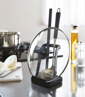 Black Lid & Ladle Stand holding cooking utensils and pot holder in kitchen by Yamazaki Home. view 13