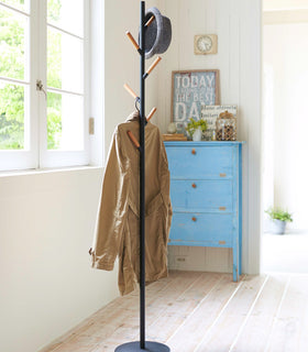 Front view of black Freestanding Coat Rack holding jacket and hat by Yamazaki Home. view 8
