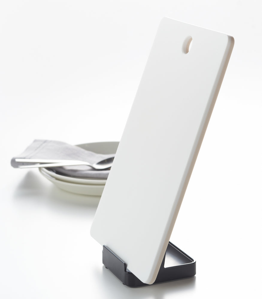 View 12 - Side view of black Lid & Ladle Stand holding cutting board on white background by Yamazaki Home.