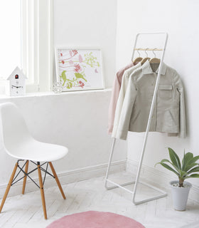White Clothes Rack holding jackets by Yamazaki Home. view 2