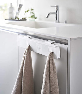 White Push Dish Towel Holder holding towels in bathroom by Yamazaki Home. view 5
