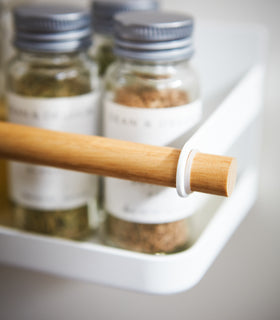 Front close up view of white Wall-Mounted Storage Caddy holding spices by Yamazaki Home. view 4