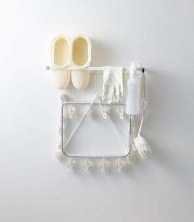 Front view of white Magnetic Clothes Hanger holding cleaning items by Yamazaki Home. view 3
