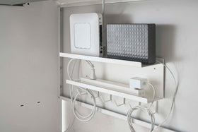 White Wall-Mount Cable and Router Storage Rack holding routers and power cord under desk by Yamazaki Home. view 6