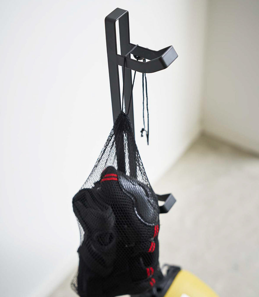 View 9 - Close up of black Kids' Helmet Stand holding protective gear by Yamazaki Home.