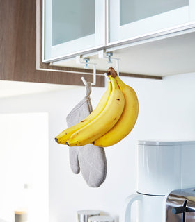 White Undershelf Hangers in kitchen holding oven mitt and bananas by Yamazaki Home. view 3