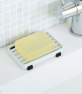 White Slotted Soap Tray on sink counter holding soap by Yamazaki Home. view 3