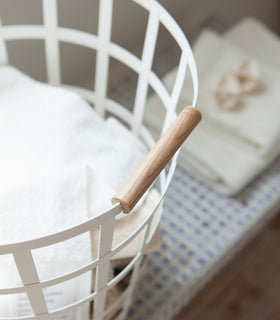 Close up aerial view of white Round Laundry Basket holding clothes by Yamazaki Home. view 6