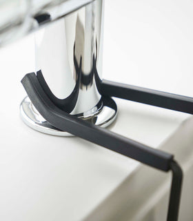 Close up of Yamazaki Home black Faucet-Hanging Sponge Caddy attached to a sink view 14