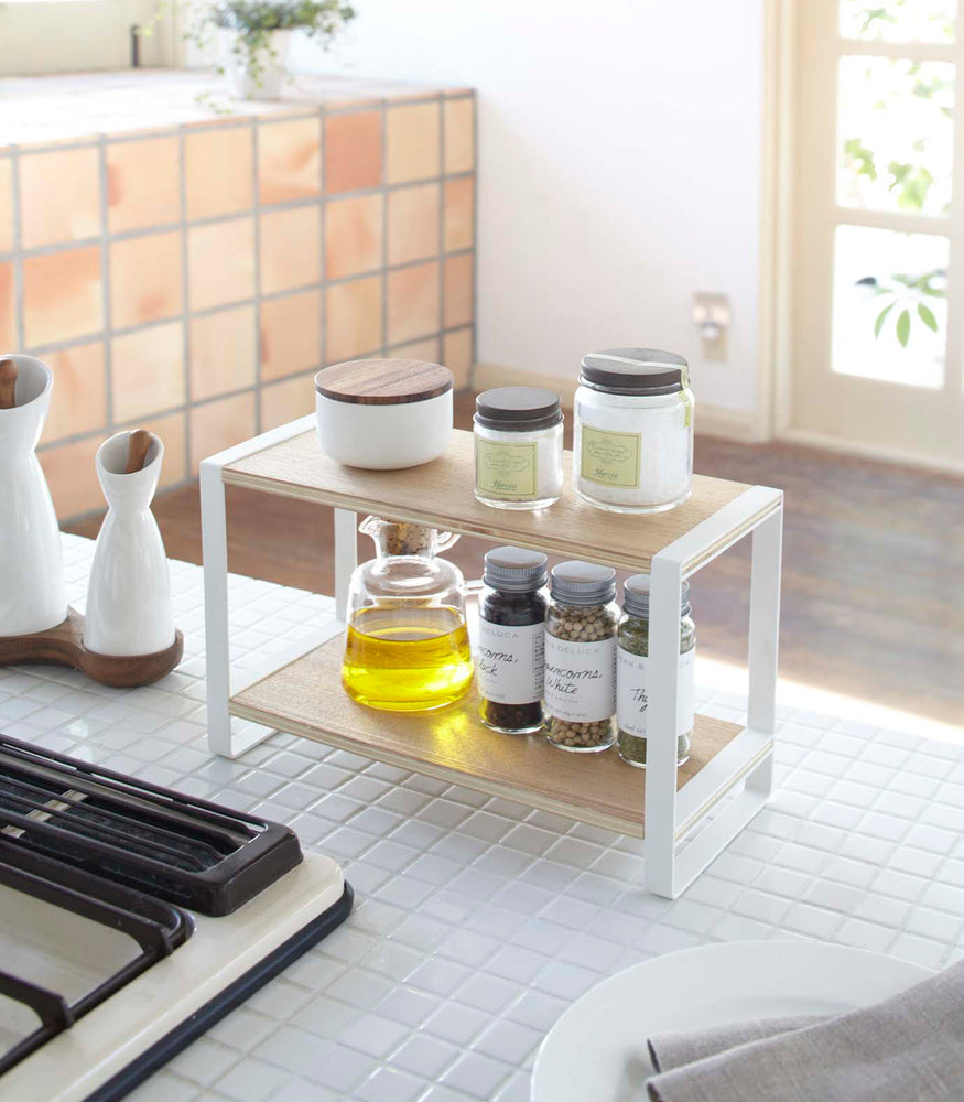 View 3 - White Countertop Shelf on kitchen counter holding spices and oil by Yamazaki Home.