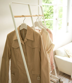 White 2-level Coat Rack holding clothes by Yamazaki Home. view 4