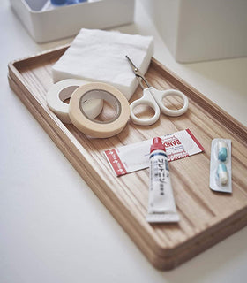Close up view of white Sewing Kit Organizer lid holding first-aid items by Yamazaki Home. view 4
