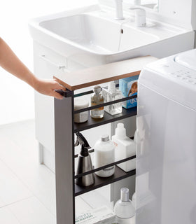 Black Rolling Storage Cart displaying cleaning supplies in bathroom by Yamazaki Home. view 14