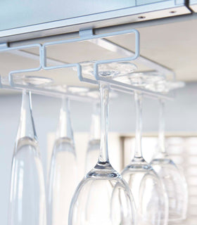 Close up view of white Undershelf Stemware Holder holding glasses by Yamazaki Home. view 5